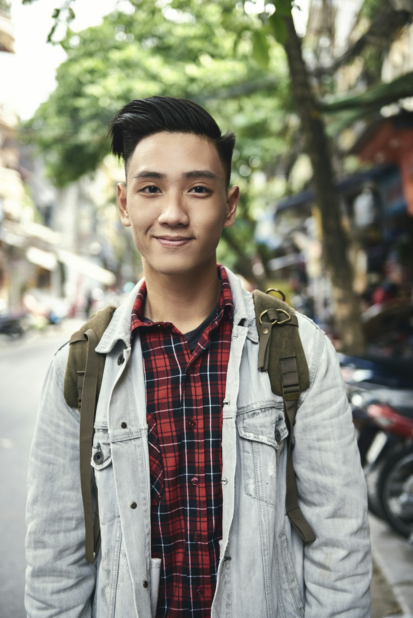 Portrait of young Vietnamese man with backpack in the city